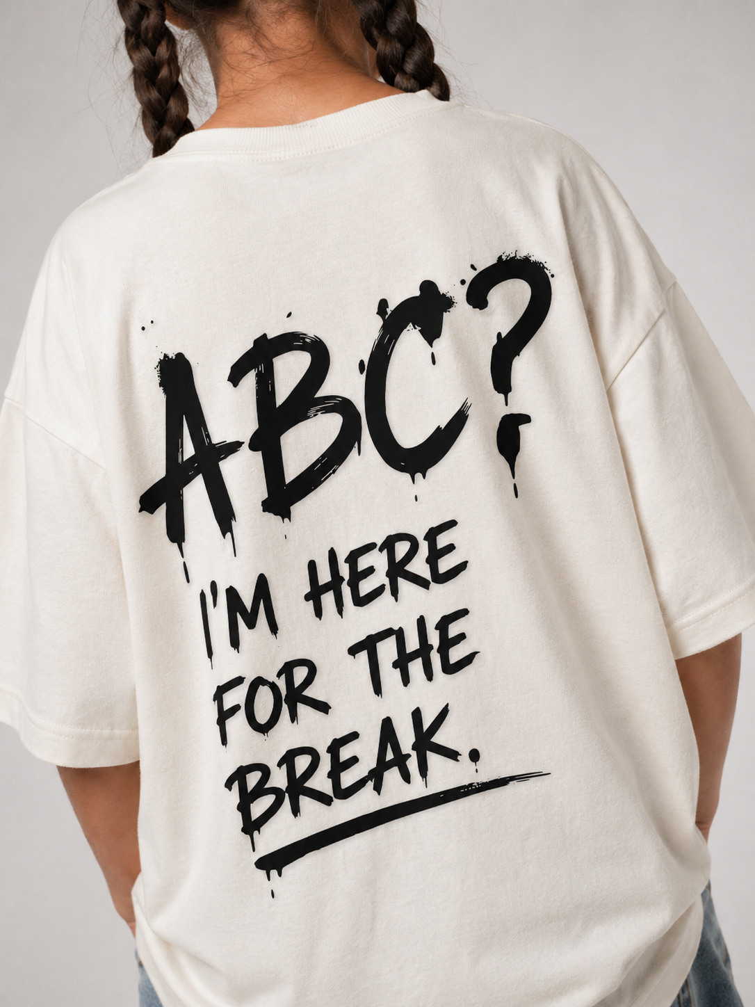 Mädchen im cremefarbenen ABC Oversize Shirt von BELOUD mit schwarzem Spray-Backprint