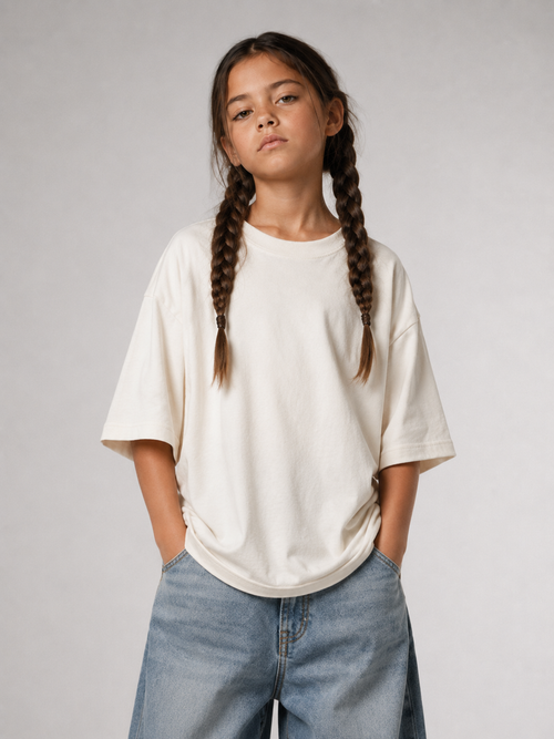Mädchen von vorne im cremefarbenen Kids Oversize Shirt von BELOUD mit Drop-Shoulder-Schnitt