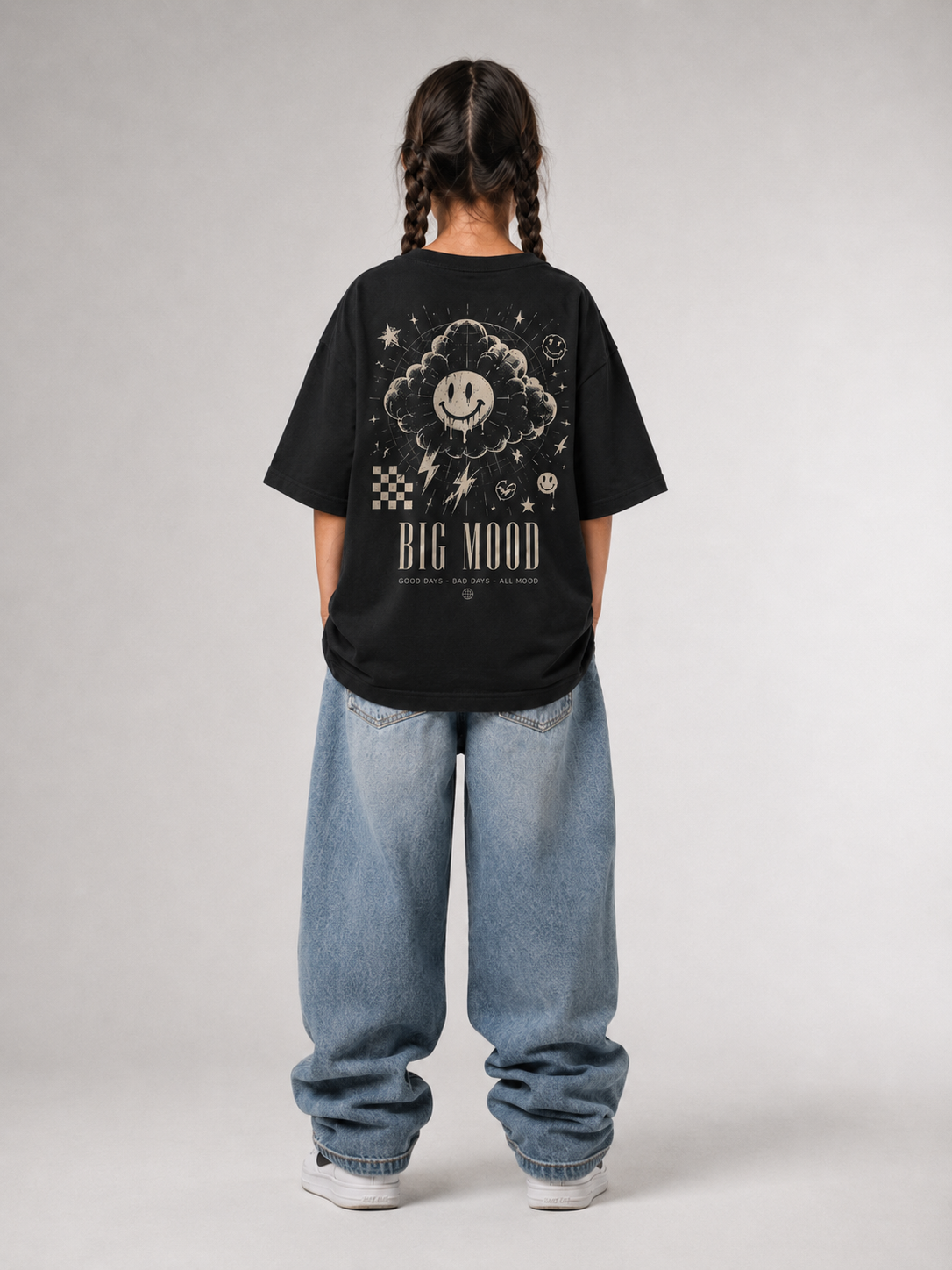 Mädchen von hinten im schwarzen BIG MOOD Oversize Shirt von BELOUD mit beigem Grunge-Smiley-Backprint