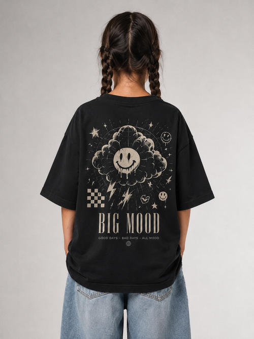 Mädchen von hinten im schwarzen BIG MOOD Oversize Shirt von BELOUD mit beigem Grunge-Smiley-Backprint