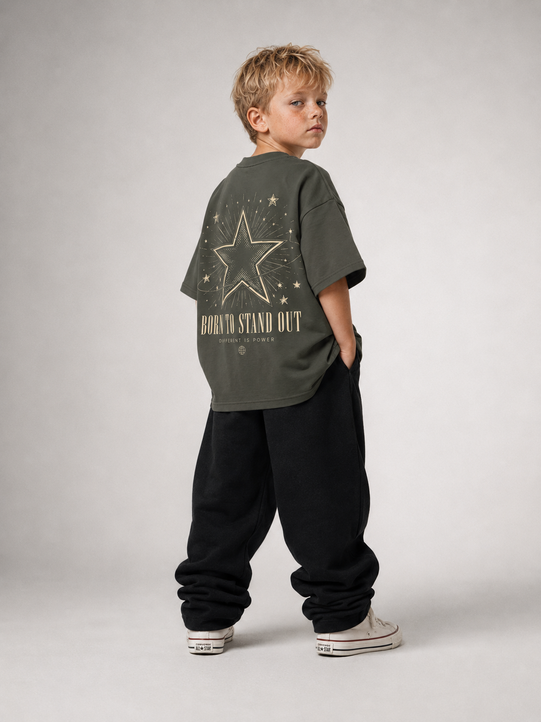 Junge von hinten im khakifarbenen BORN TO STAND OUT Oversize Shirt von BELOUD mit cremefarbenem Stern-Backprint