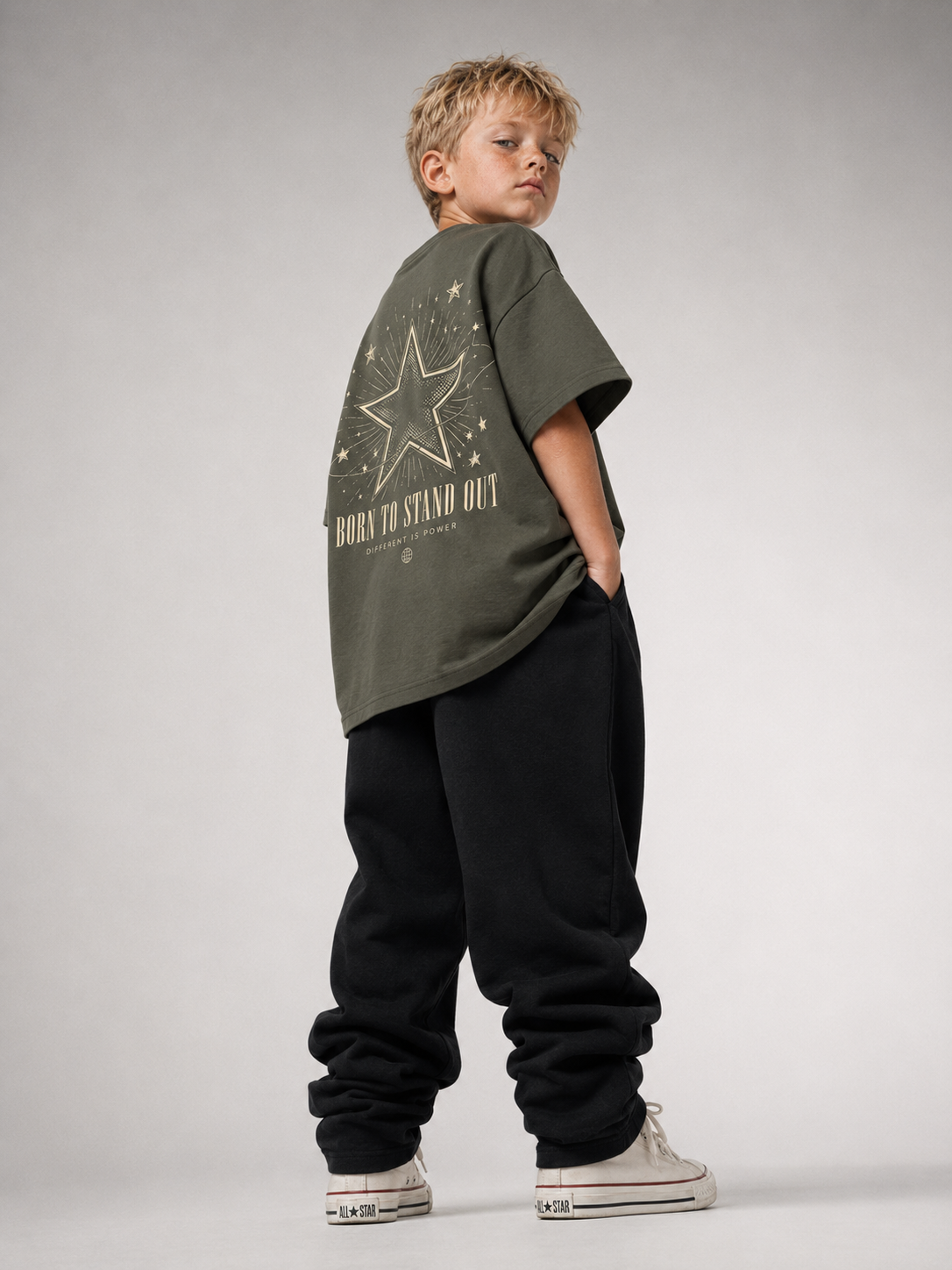 Junge von hinten im khakifarbenen BORN TO STAND OUT Oversize Shirt von BELOUD mit cremefarbenem Stern-Backprint