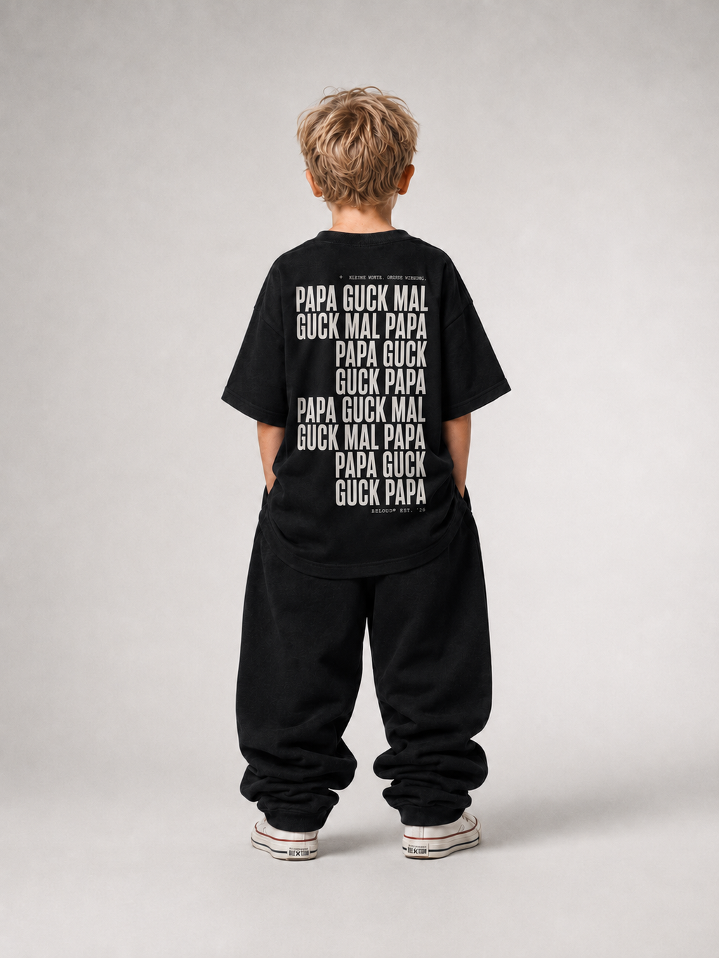 Kind von hinten im schwarzen GUCK MAL PAPA Oversize Shirt von BELOUD mit weißem Repeat-Text-Backprint