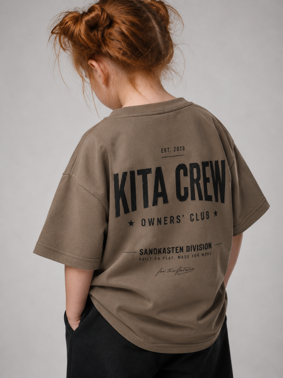 Mädchen von hinten im driftwoodfarbenen KITA CREW Oversize Shirt von BELOUD mit schwarzem Varsity-Backprint