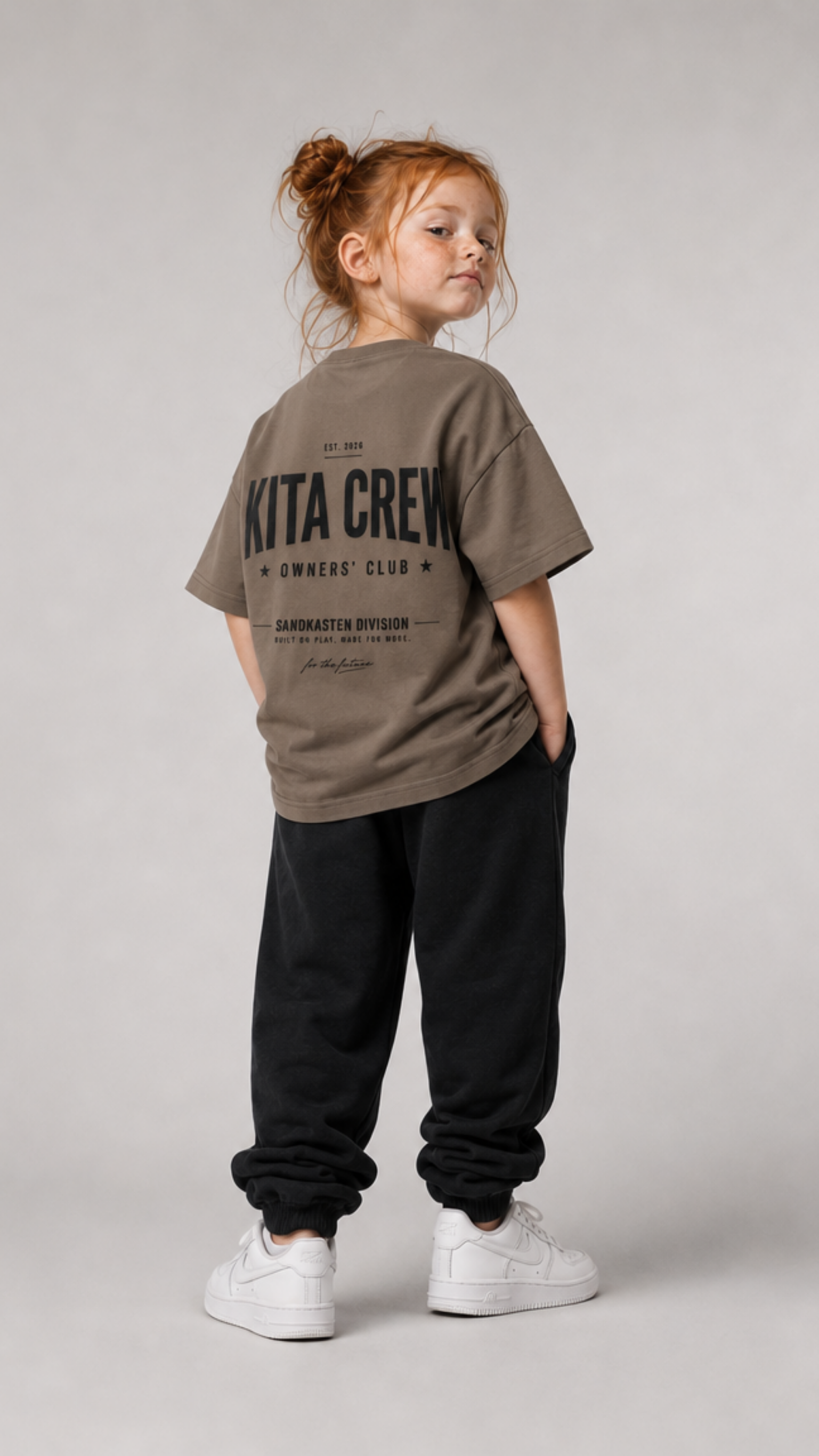 Mädchen von hinten im driftwoodfarbenen KITA CREW Oversize Shirt von BELOUD mit schwarzem Varsity-Backprint