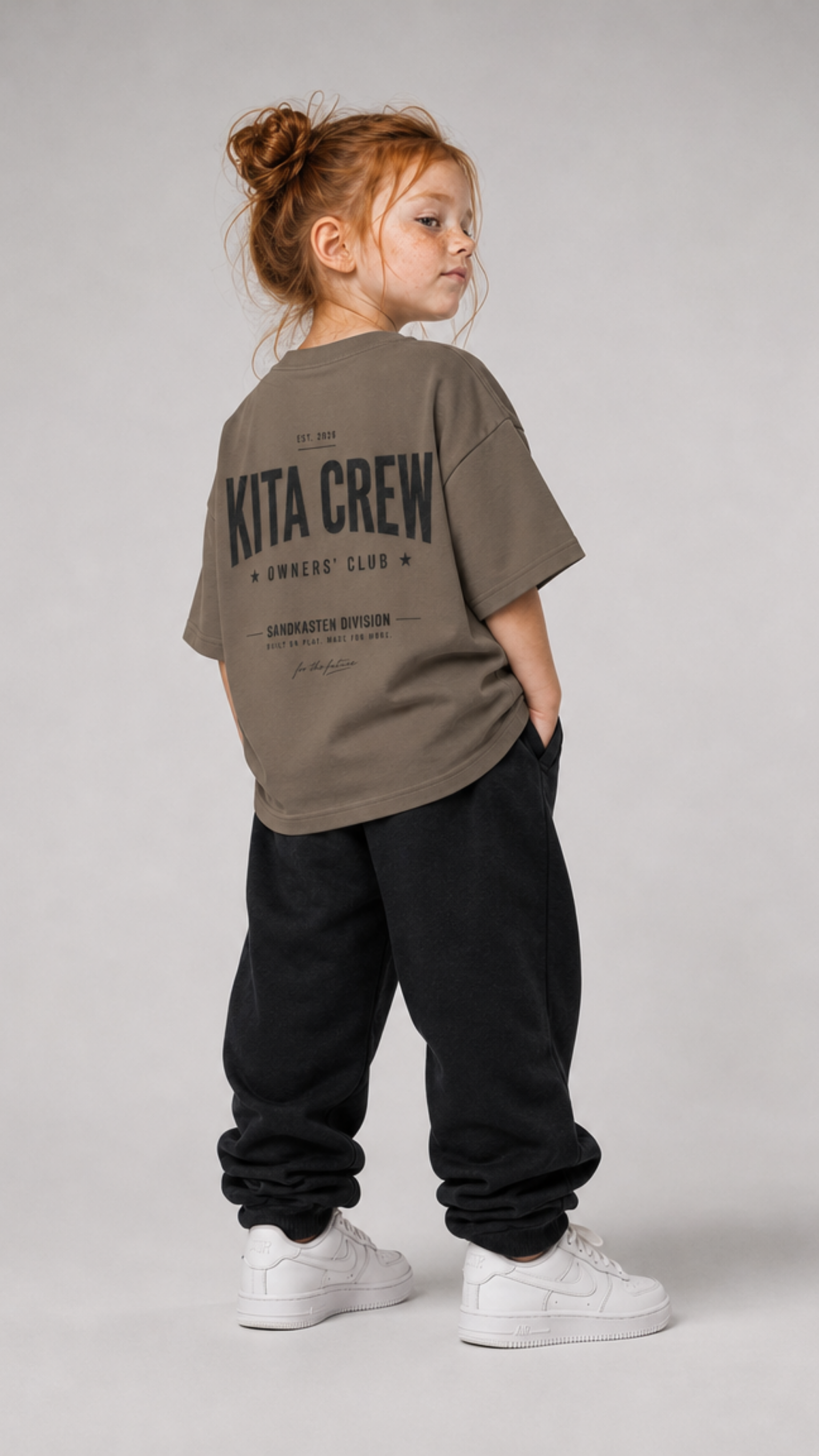Mädchen von hinten im driftwoodfarbenen KITA CREW Oversize Shirt von BELOUD mit schwarzem Varsity-Backprint