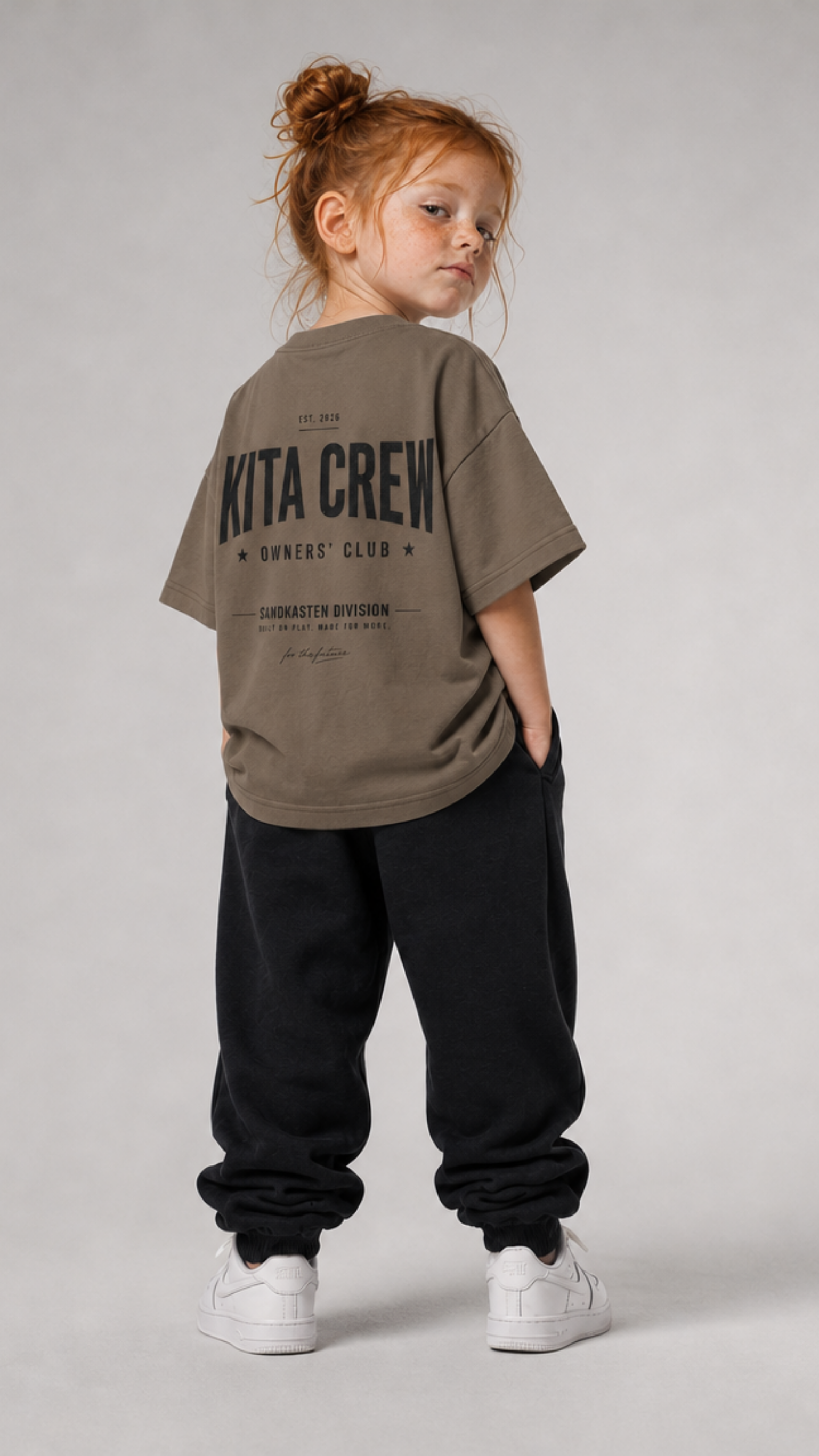 Mädchen von hinten im driftwoodfarbenen KITA CREW Oversize Shirt von BELOUD mit schwarzem Varsity-Backprint