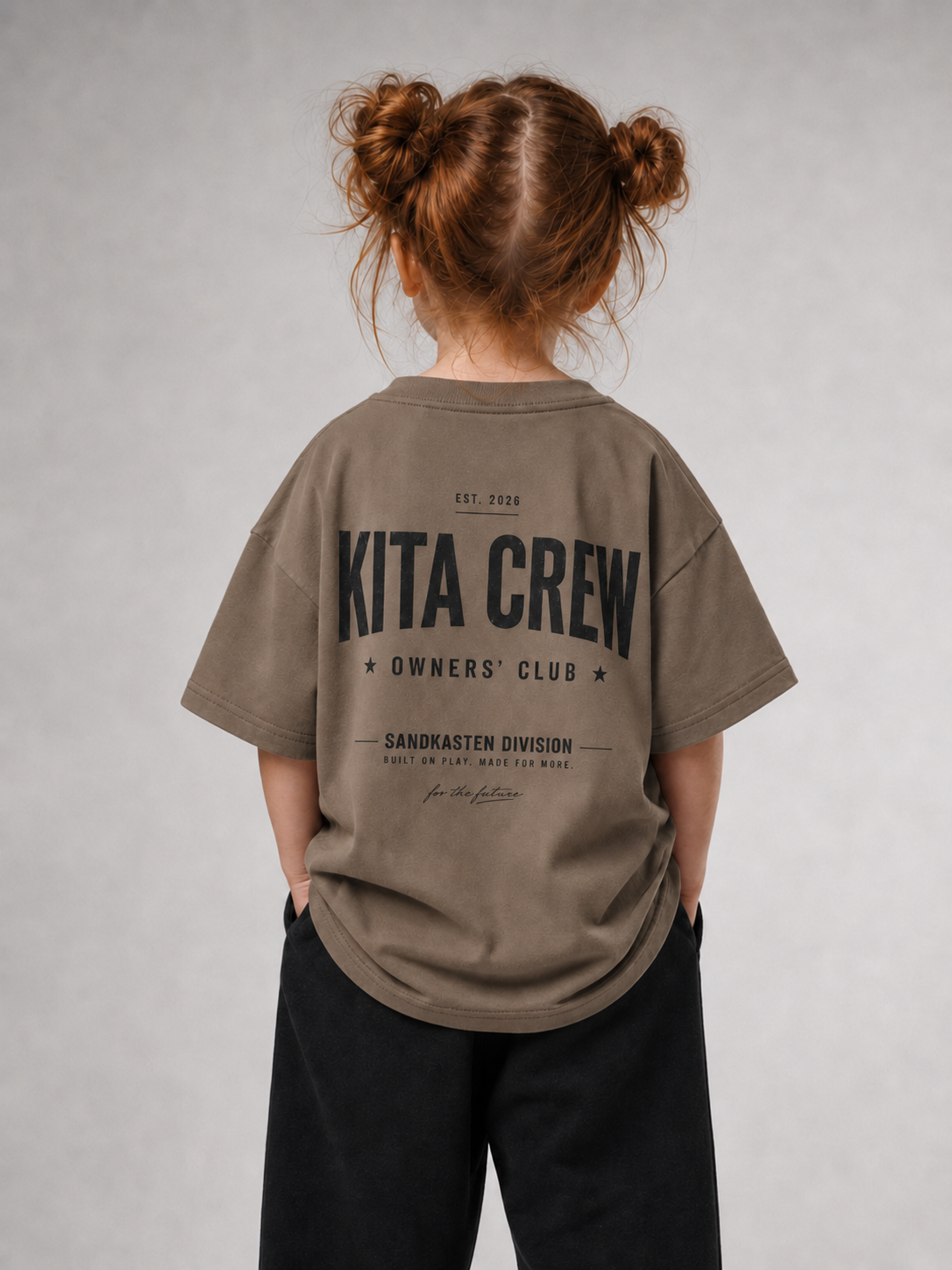 Mädchen von hinten im driftwoodfarbenen KITA CREW Oversize Shirt von BELOUD mit schwarzem Varsity-Backprint