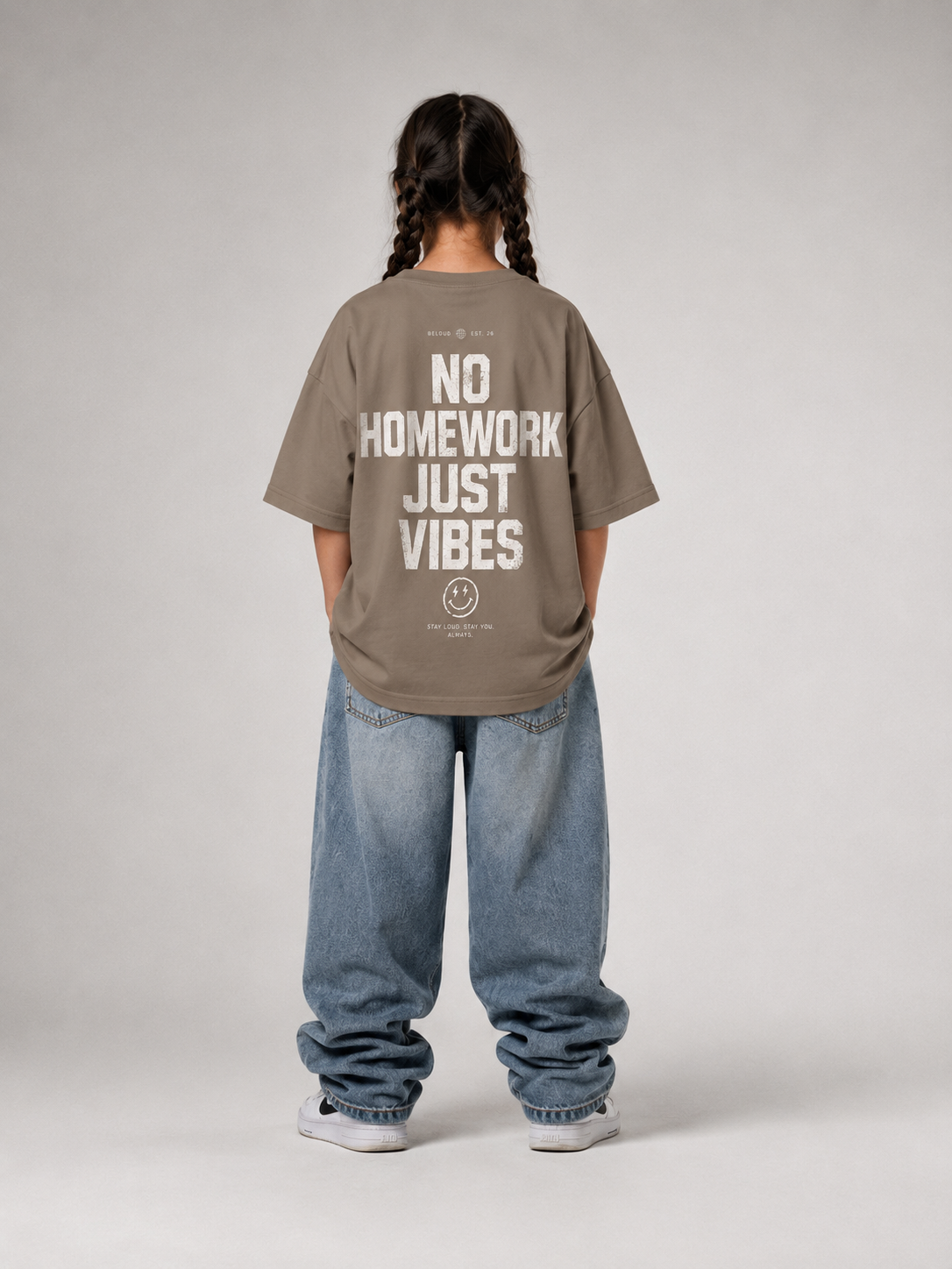 Mädchen von hinten im driftwoodfarbenen NO HOMEWORK JUST VIBES Oversize Shirt von BELOUD mit cremefarbenem Statement-Backprint