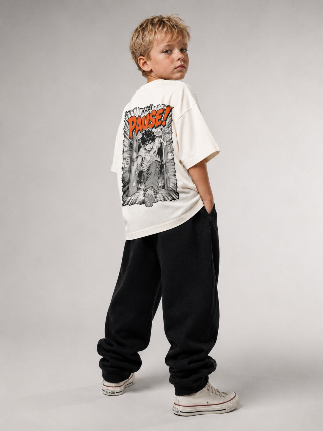 Junge von hinten im cremefarbenen PAUSE Oversize Shirt von BELOUD mit schwarz-orangem Manga-Backprint