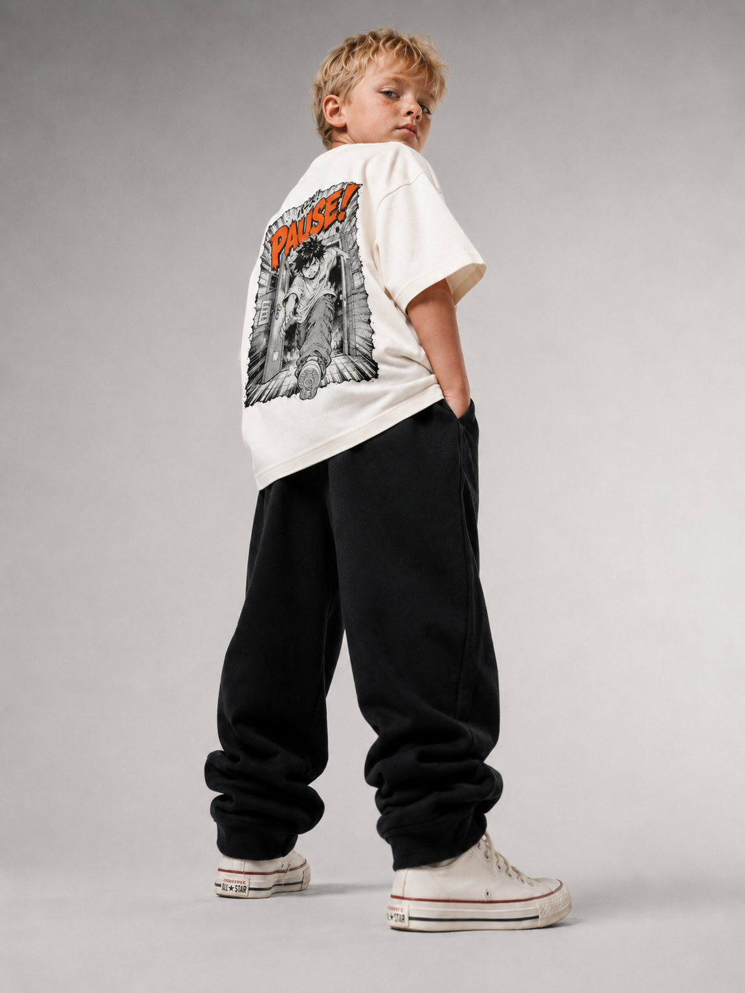 Junge von hinten im cremefarbenen PAUSE Oversize Shirt von BELOUD mit schwarz-orangem Manga-Backprint