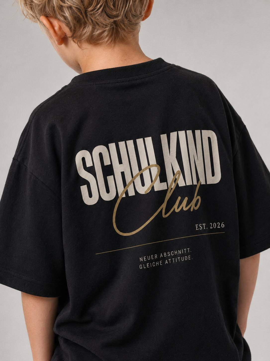 Junge im schwarzen SCHULKIND CLUB Oversize Shirt von BELOUD mit beige-goldenem Backprint