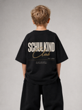 Junge von hinten im schwarzen SCHULKIND CLUB Oversize Shirt von BELOUD mit beige-goldenem Backprint