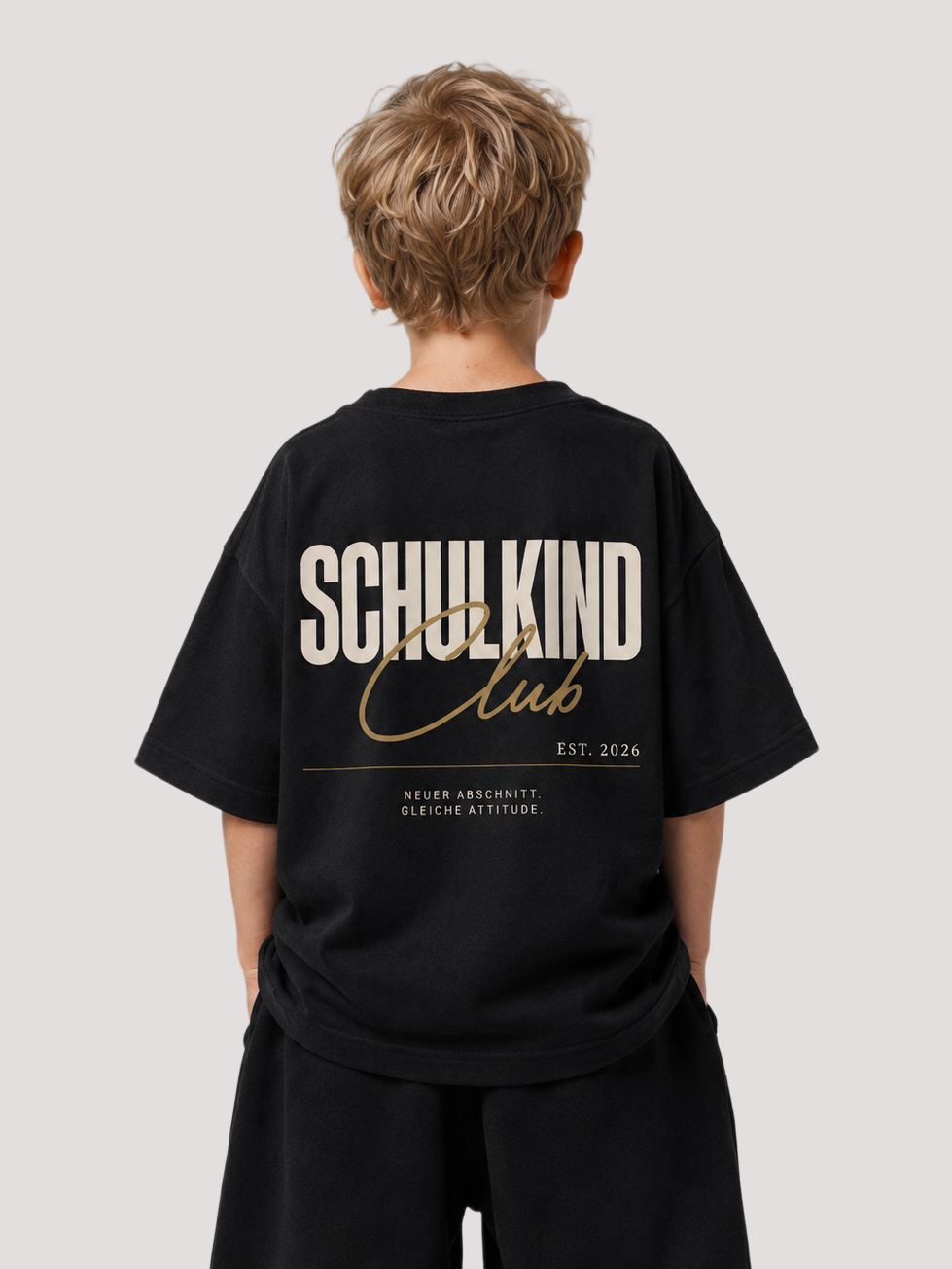 Junge von hinten im schwarzen SCHULKIND CLUB Oversize Shirt von BELOUD mit beige-goldenem Backprint