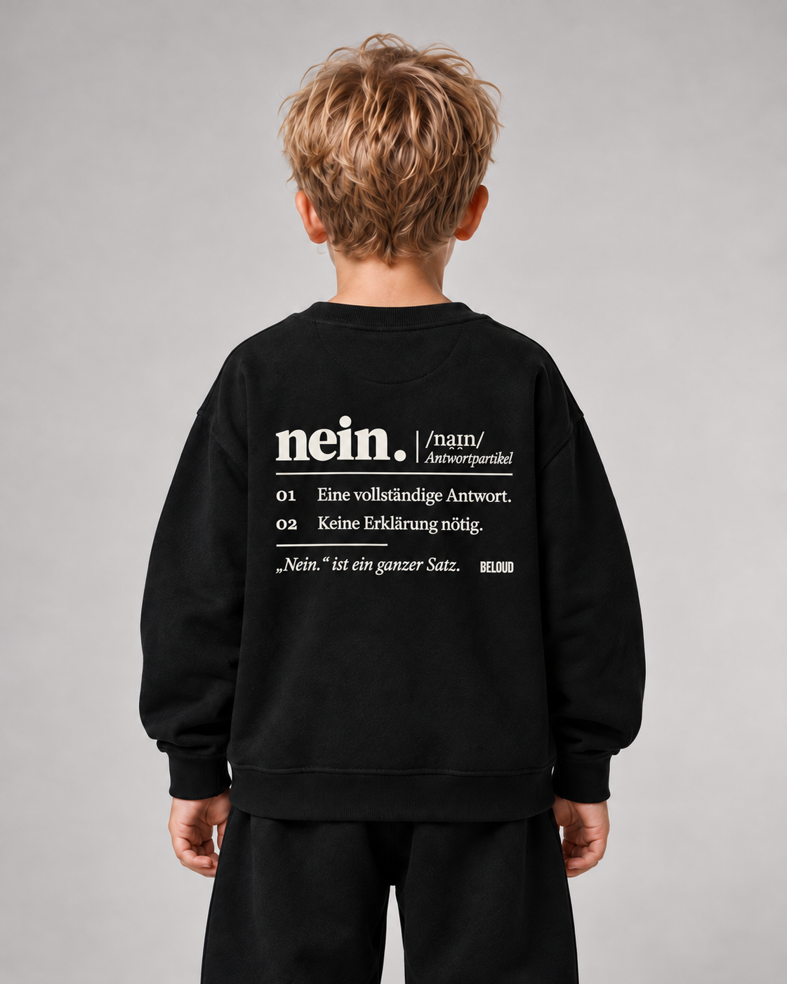 Schwarzer NEIN Kinder-Sweater mit weißem Rückenprint, getragen von einem blonden Jungen