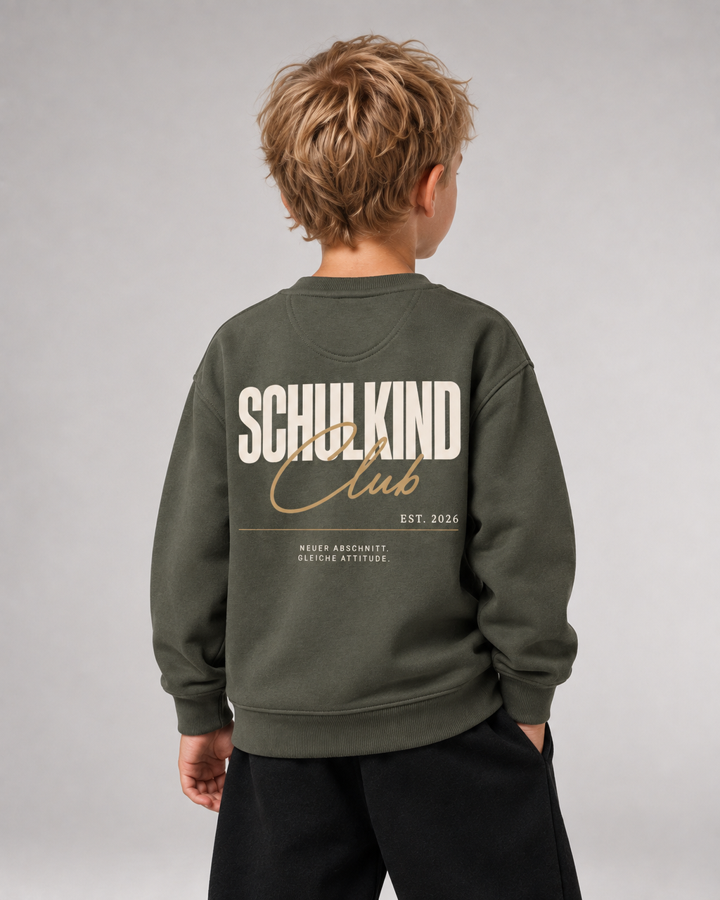 Junge trägt SCHULKIND CLUB 2026 Kids Sweater in Organic Khaki – Rückansicht